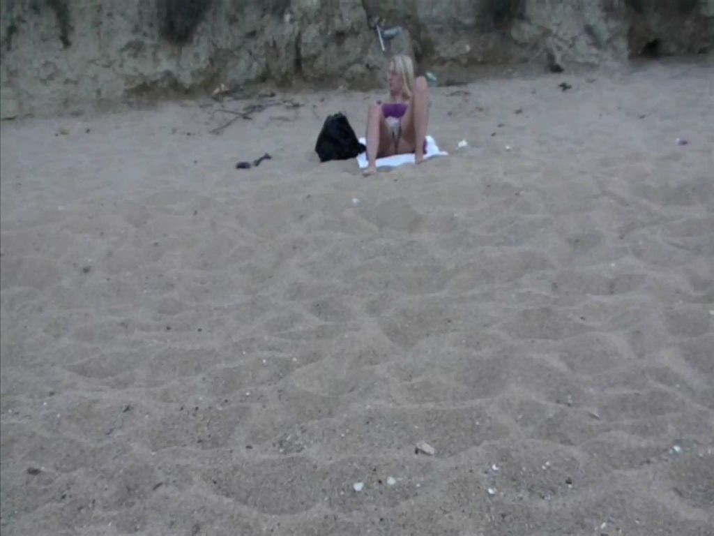 Blondes Teeny macht es sich am Strand selber